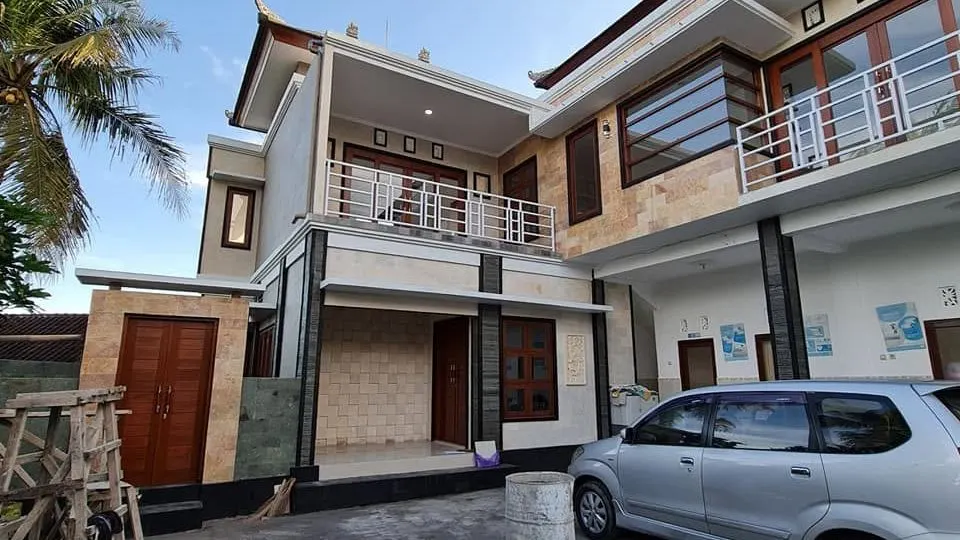 Finished two-storey house with stone cladding, balconies, and a car porch