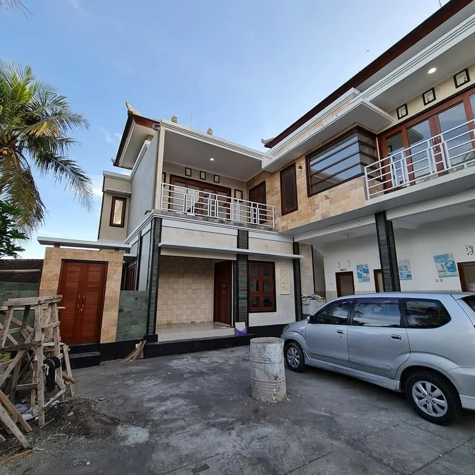 Finished two-storey house with stone cladding, balconies, and a car porch