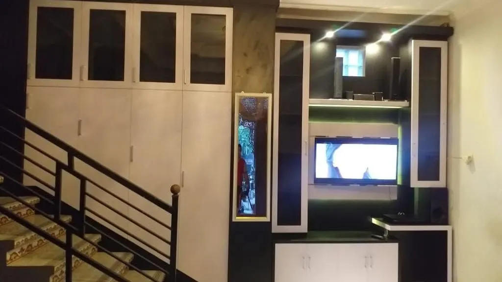 Built-in cabinet and TV unit beside a staircase