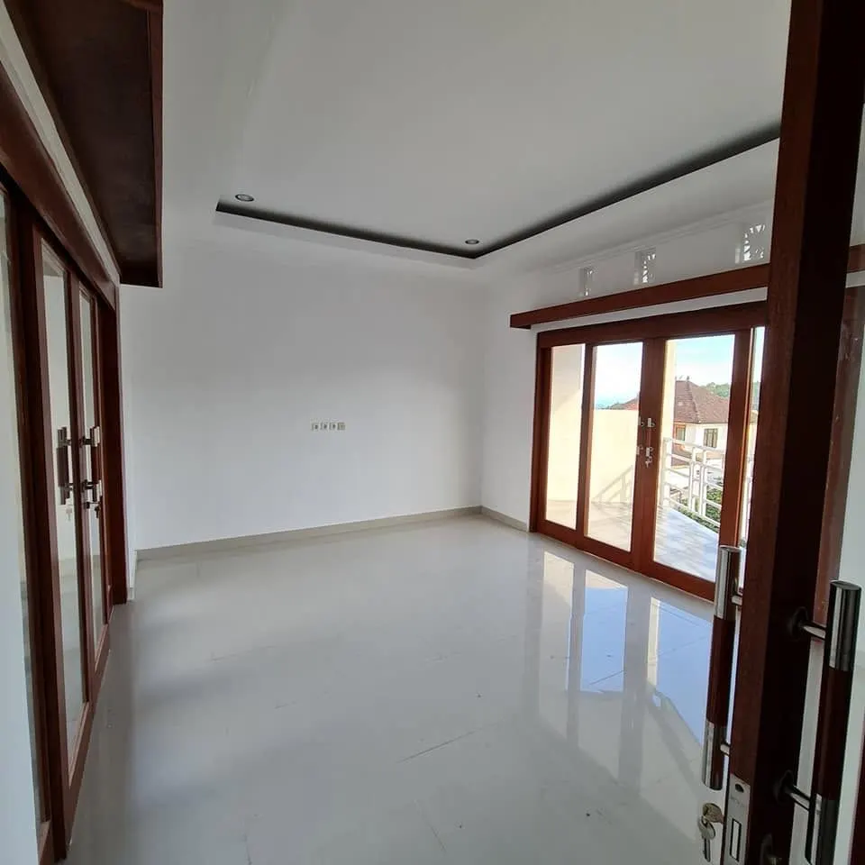 Empty finished room with large windows and a drop ceiling