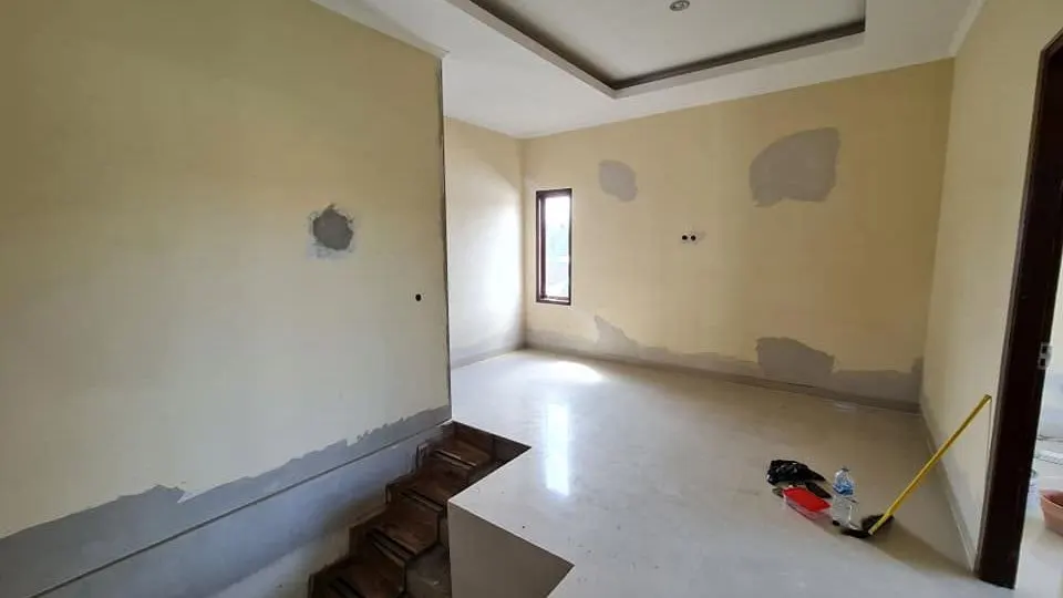 Upper-floor hall during finishing, with the stair opening
